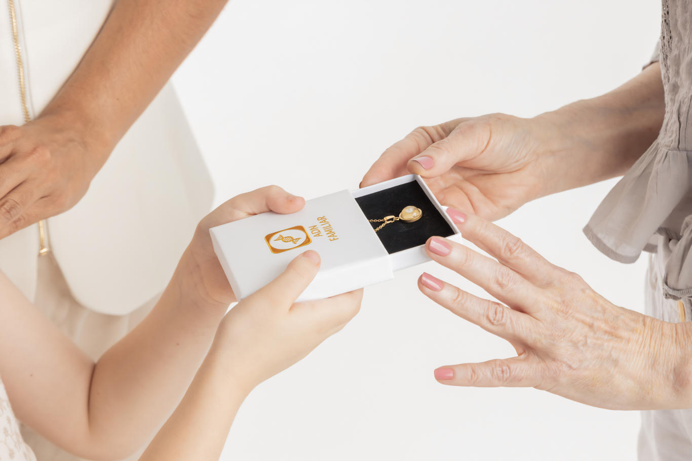 Caja de regalo ADN Familiar Manos intercambiando una caja blanca con un collar dorado en su interior.