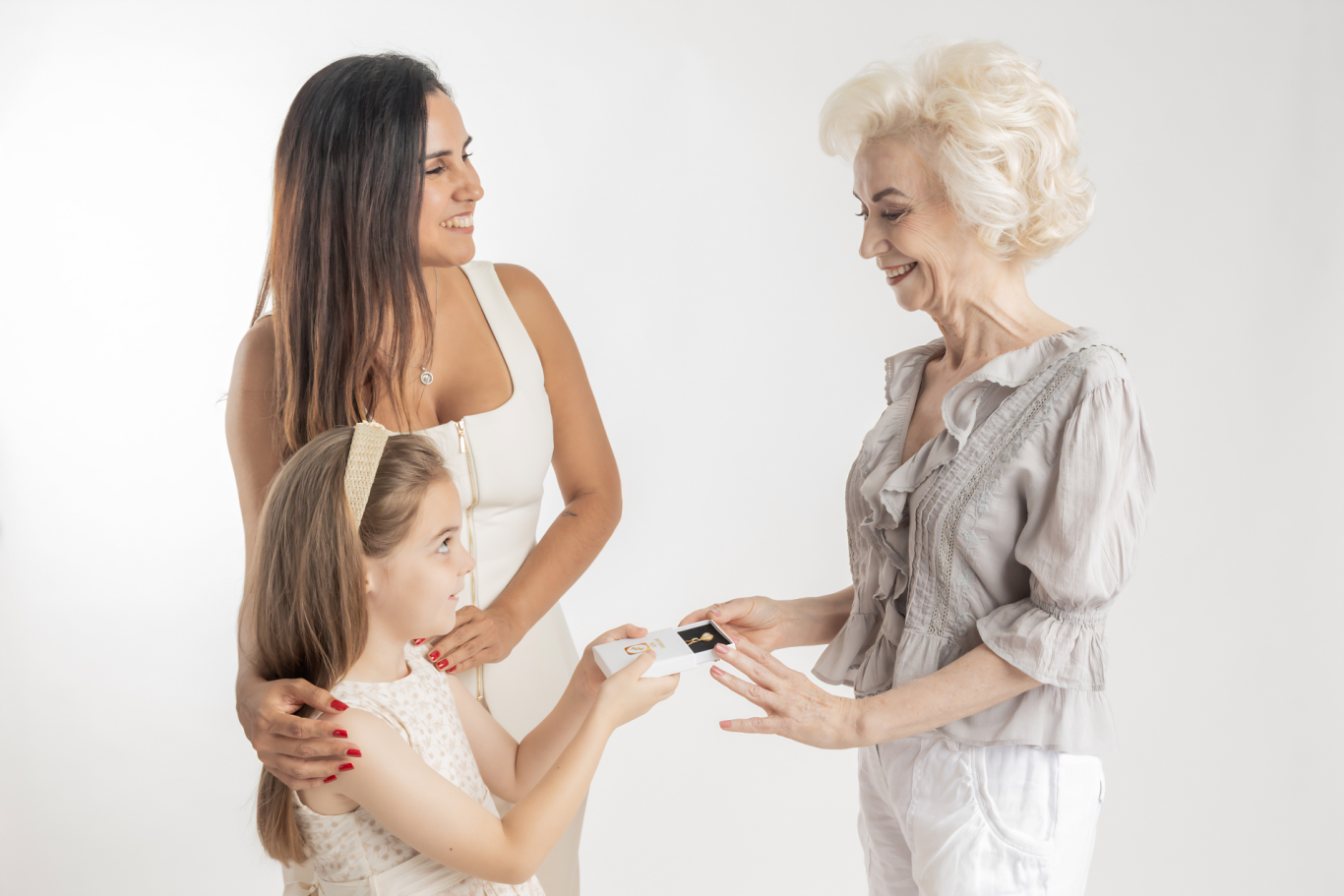 Familia ADN Familiar Tres mujeres de diferentes generaciones comparten un momento, sonriendo y interactuando.